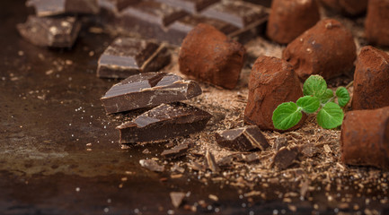 Homemade chocolate truffles with mint on a dark background. Delicious gourmet candy. Selective focus, copy space