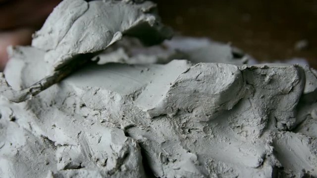 Cutting clay from plastic arts with sculpture tools.