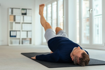 Man doing leg stretch and raise exercises