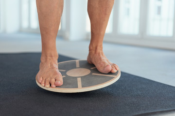 Feet of a man working out on a balance board