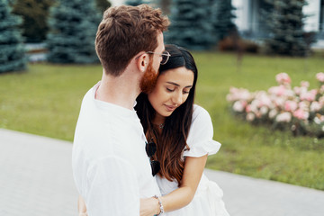 Naklejka premium Young happy couple hugging on the city street