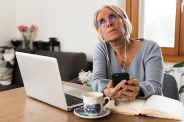 thoughtful woman working on laptop at home