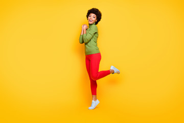 Fototapeta na wymiar Turned full length body size photo of cheerful positive cute pretty nice girl in red pants trendy smiling toothily in white foot wear isolated vivid color background