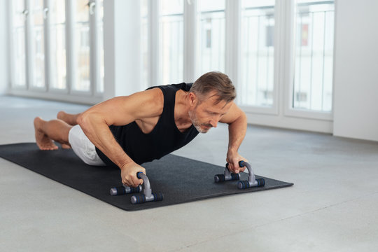 Strong healthy middle-aged man doing push ups