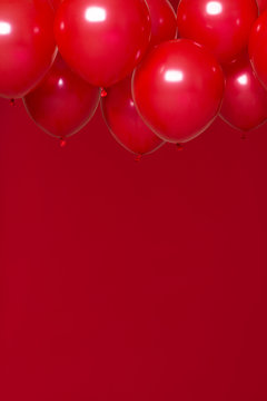 red helium balloons on red background