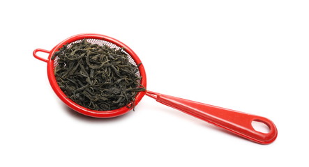 Green tea pile with red metal kitchen sieve, sifter isolated on white background