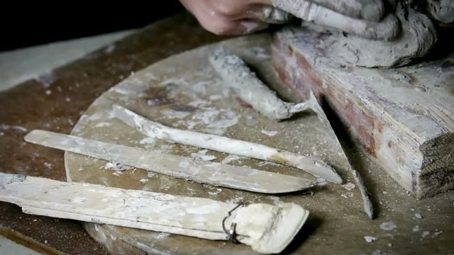 Sculptor Uses Tool To Sculpt Side Of Statue. Sculptor at work.