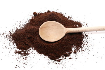 Milled coffee powder for espresso with wooden spoon isolated on white background