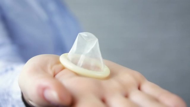 Man takes a condom from a woman on a white background