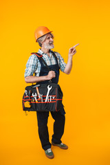 Man builder in helmet equipment instruments pointing aside.