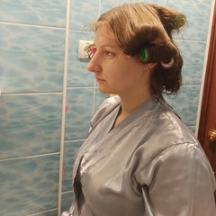 Woman with hair curlers in hair at bathroom