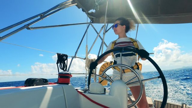 Front view of a gorgeous woman navigating a yacht