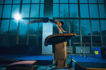 Little male gymnast training in gym, flexible and active. Caucasian fit little boy, athlete in...