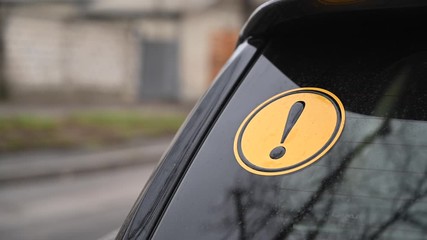 Beginner driver yellow round sign on a car