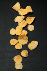 Crispy potato chips on dark