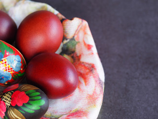 Natural Easter eggs and wooden painted eggs on a napkin close-up. Colorful and bright picture for the spring holiday Easter.