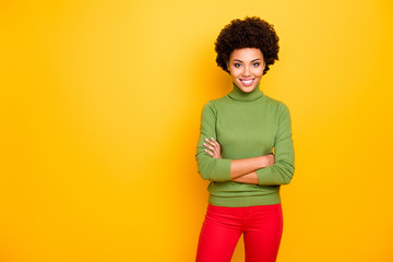 Photo of wavy cheerful toothy beaming woman in red pants with arms crossed near empty space isolated vibrant color background