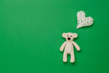 Bear toy and natural heart for baby on green background