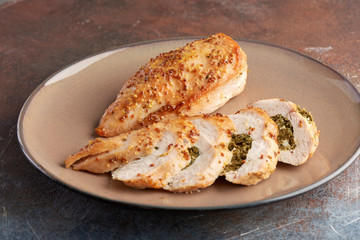 chicken breast stuffed with spinach on a grey plate on a grey background