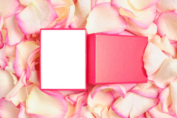 Red gift box for copy space against the background of pink petals.