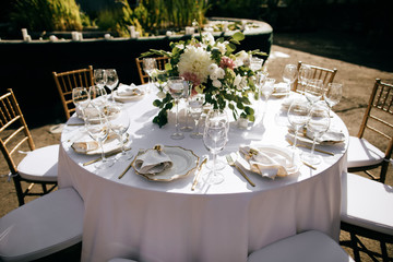 elegant table setting with  floral decor in the garden, outdoor catering service