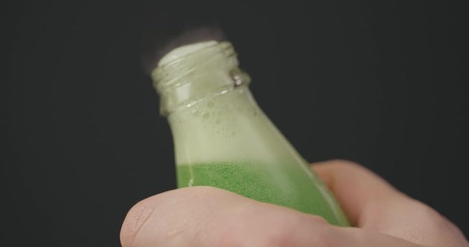 Man opens coke bottle with screw top by hands. Male fingers open soda on black background