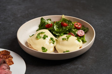 Eggs benedict with bacon meat and fish, close-up
