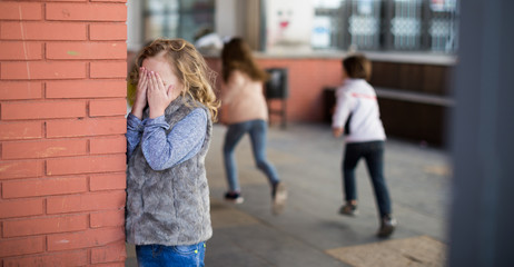 playing hide and seek. Girl covering eyes her hands standing