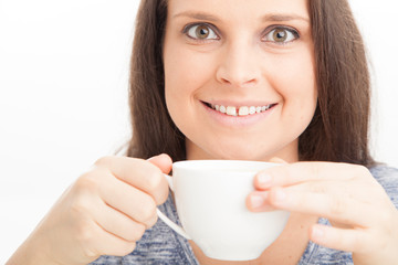 Close up of Female holding cup of tea of coffee, wearing blue on white background