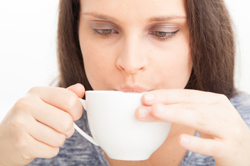 Blowing on hot cup of tea or coffee