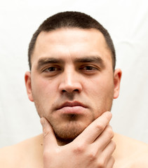 Obraz premium man thinks shave his beard or not