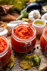 Colorful tabletop scene with raw ajvar surrounded with vegetables. Vegan chutney flat lay scene. Healthy eating