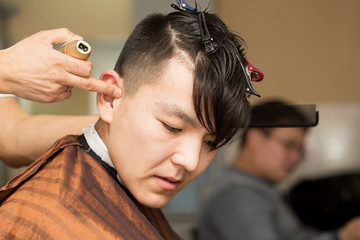 Naklejka premium hairdresser cutting customer's hair