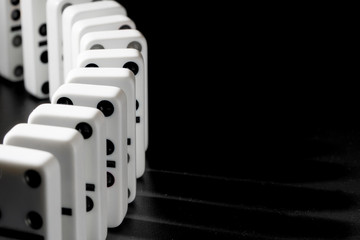Domino pieces put in a row on black background