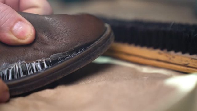 Shoe repair - glue the soles on the old boots. Close-up.