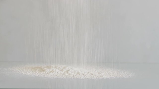 White flour on glass background. Spilled flour.