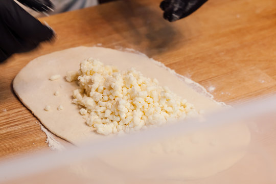 Cook hands preparing khachapuri in a cafe close upv