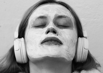 Portrait of young woman with a mask on the face listening to music