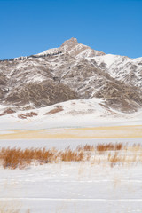 Snow mountain and snow field grassland near by the Xinjiang China Sayram lake. Winter season.