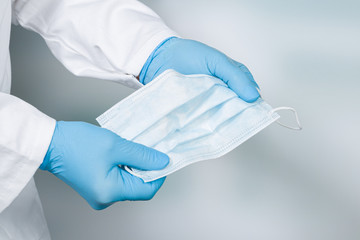 close up of doctor's hand with a medical face mask for protection against infection