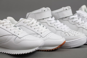 White sneakers on a gray background. Sport shoes. A lot of shoes.