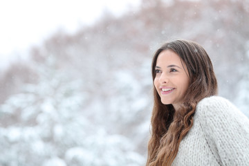 Happy girl watching snow falling in the mountain