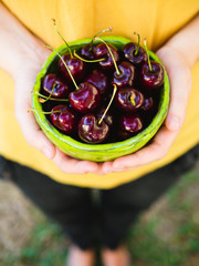 Holding a bowl of cherries