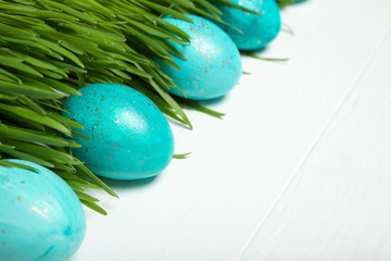 Easter eggs in fresh green grass. On white background