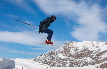 Fototapeta na wymiar Skier jumps in the snowy mountains