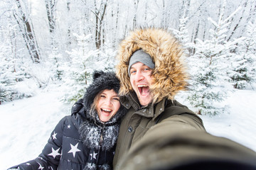 Man taking selfie photo young romantic couple smile snow forest outdoor winter
