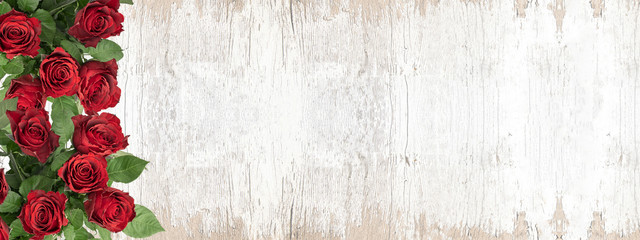 Bunch bouquet of red roses on white vintage wooden texture background banner panorama, top view with space for text © Corri Seizinger