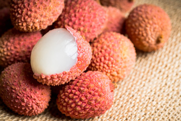 Red ripe lychees on the rustic background. Selective focus. Shallow depth of field.