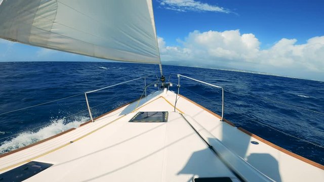 First-person view from a yacht sailing across the sea. Sailing boats in blue ocean waters ina sunny day.