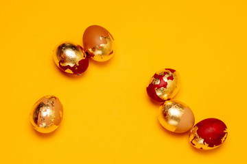 Assorted golden chicken eggs on a yellow background